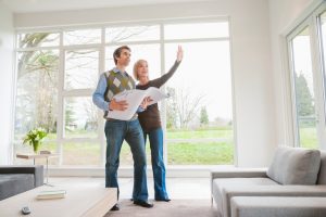 Couple holding building plans and discussing remodel