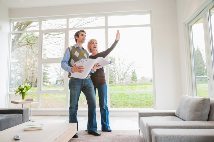 couple holding building plans and discussing remodel